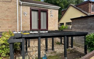 Work in progress building the subframe for steps leading down to the back garden from the back door of a property created using Millboard's smoked oak decking with a black railing