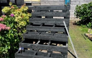 Work in progress building the subframe for steps leading down to the back garden from the back door of a property created using Millboard's smoked oak decking with a black railing