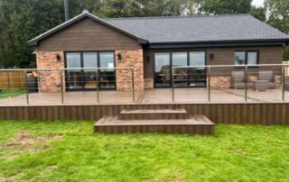 Millboard Composite Decking in Antique Oak Waterlooville 16 Far front shot of a large composite decking porch installed to a house in Waterlooville