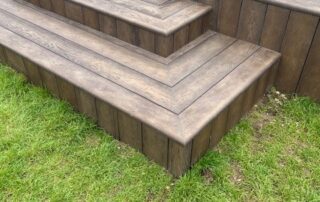 Millboard Composite Decking in Antique Oak Waterlooville 4 Close view of stairs of a large composite decking porch installed to a house in Waterlooville