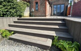 Millboard Composite Decking in Ebony Grey – Arundel, West Sussex 1 Composite decking installed forming stairs off of the porch in a garden in Arundel