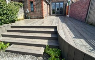 Millboard Composite Decking in Ebony Grey – Arundel, West Sussex 2 Composite decking installed forming stairs off of the porch in a garden in Arundel