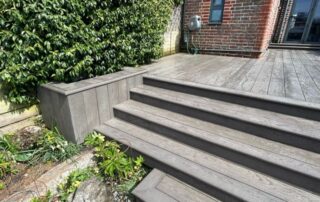 Millboard Composite Decking in Ebony Grey – Arundel, West Sussex 5 Composite decking stairs installed forming stairs off of the porch in a garden in Arundel