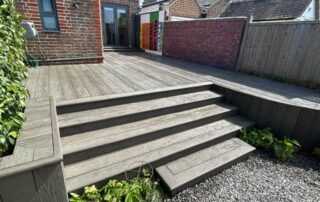 Millboard Composite Decking in Ebony Grey – Arundel, West Sussex 6 Composite decking installed forming stairs off of the porch in a garden in Arundel